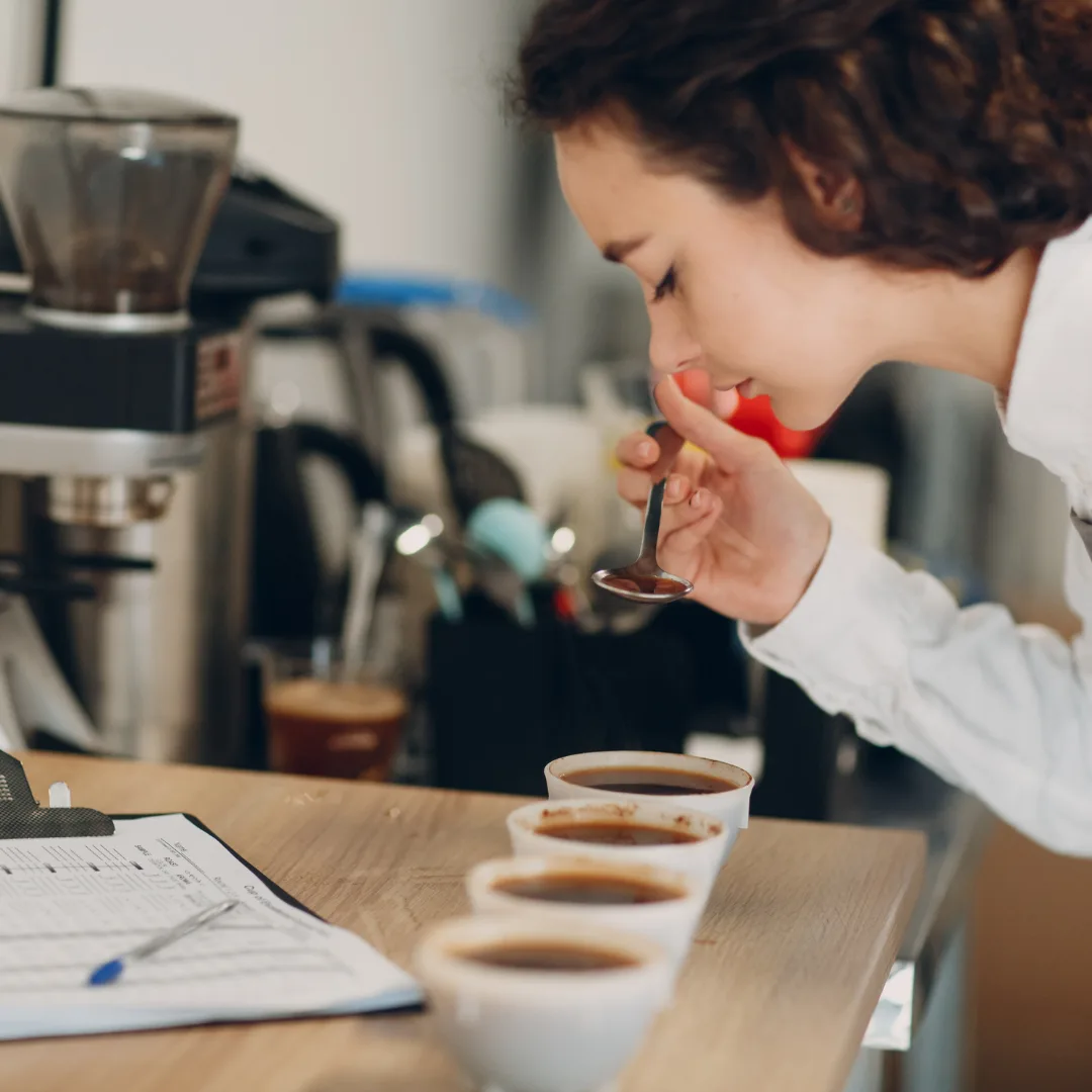 Picture of woman tasting coffee for the best tasting decaf coffee for keurig.