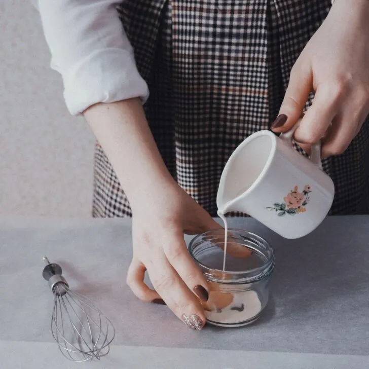 Picture of woman pouring creamer into a container to be whisked. Can you froth creamer?
